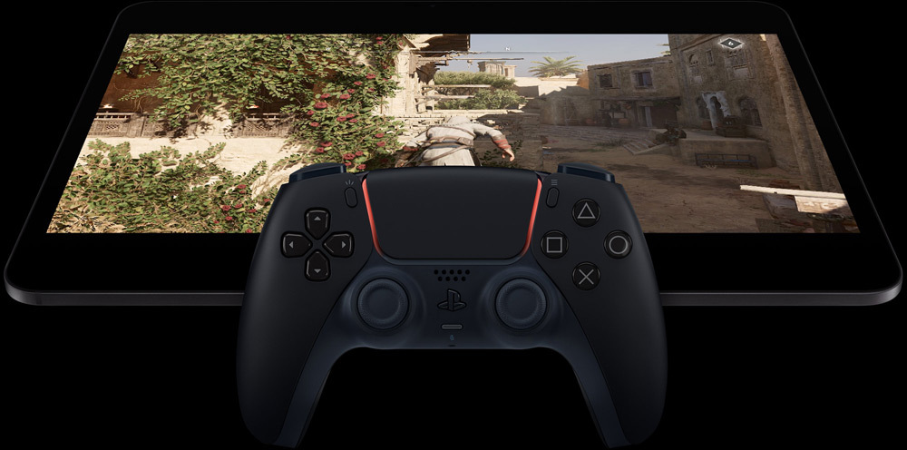 Un iPad Pro in orizzontale che mostra la scena di un videogioco, con davanti un controller Playstation