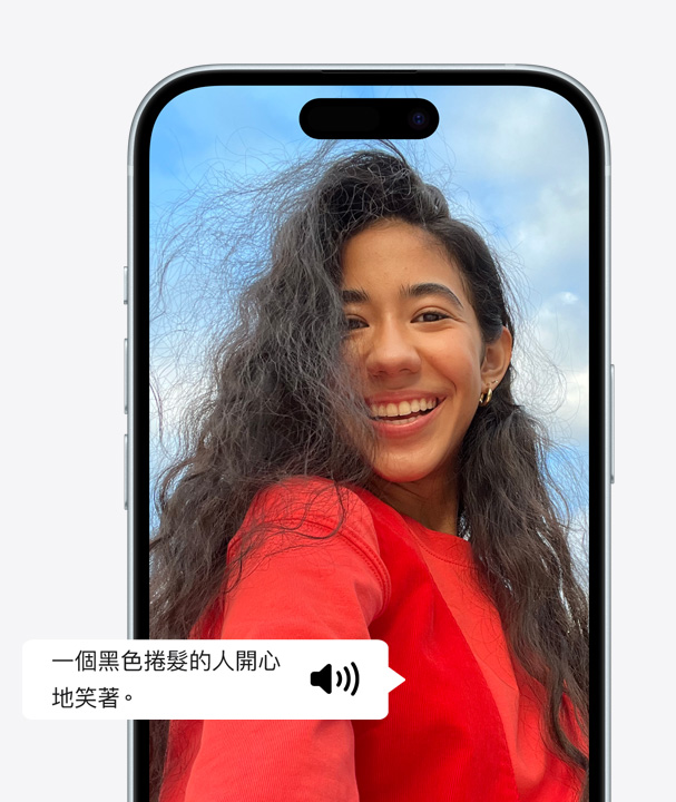 圖片展示在 iPhone 上使用旁白功能，詳細描述畫面上留著捲髮的女人露齒開心大笑。