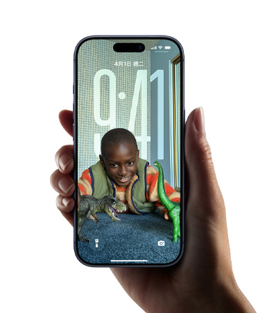 一隻手拿著 iPhone 裝置,展示全新 Liquid Glass 設計,讓時間顯示隨鎖定畫面上的影像動態調整
