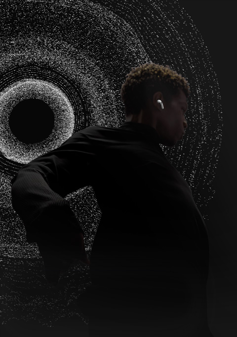 A person dances in front of a background of spherical sound particles representing the immersive sound of Spatial Audio