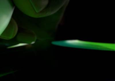 Egy kéz írásra kész helyzetben tartja az Apple Pencil Prót. A ceruzahegy egy képernyőhöz ér, amelyen fénylő zöld színnel húzott vastag vonások látszanak.