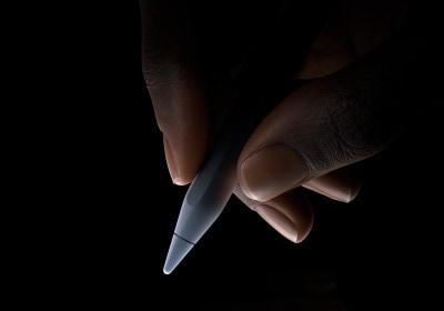Egy felhasználó írásra kész helyzetben tartja hüvelyk- és mutatóujja között az Apple Pencil Prót a szár alsó harmadánál fogva.