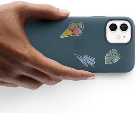 Una mano sostiene un iPhone 12 con stickers.