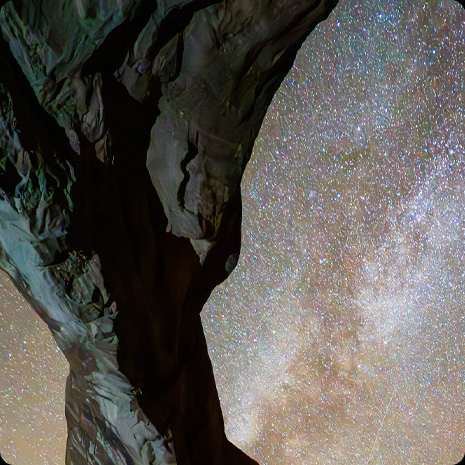 Foto av en klippformation mot en stjärnbeströdd natthimmel