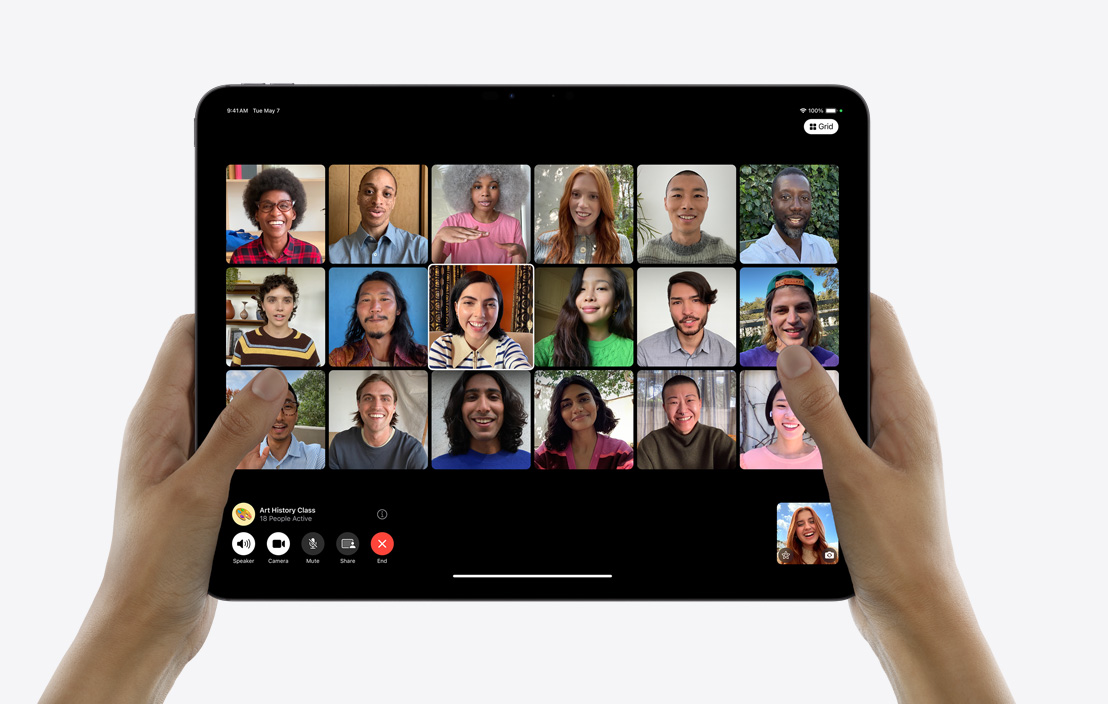 Een paar handen houden een iPad Pro vast waarop in FaceTime een groepsgesprek wordt gevoerd.