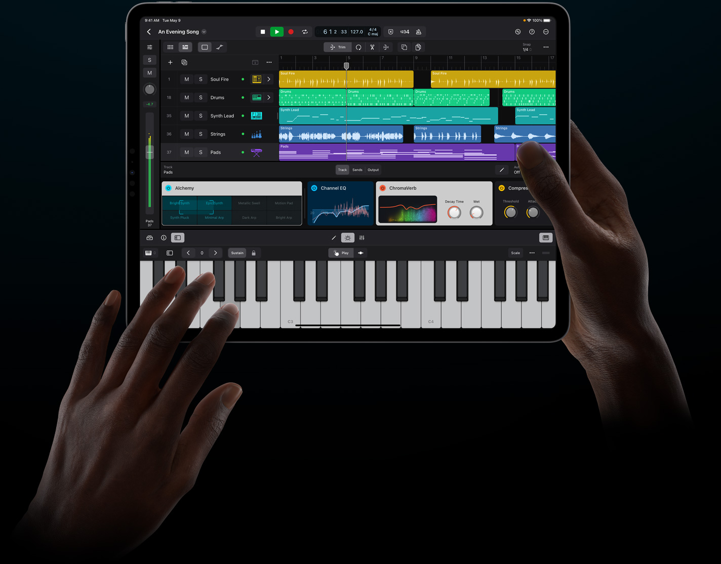 Duas mãos seguram um iPad Pro e tocam um instrumento virtual no Logic Pro para iPad.