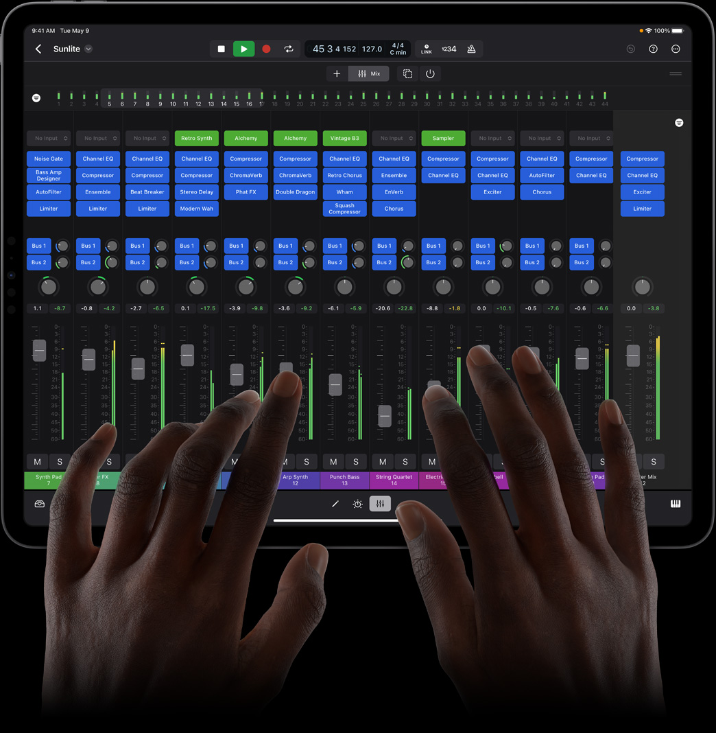Unas manos controlan una mesa de mezclas en Logic Pro para el iPad usando un iPad Pro.