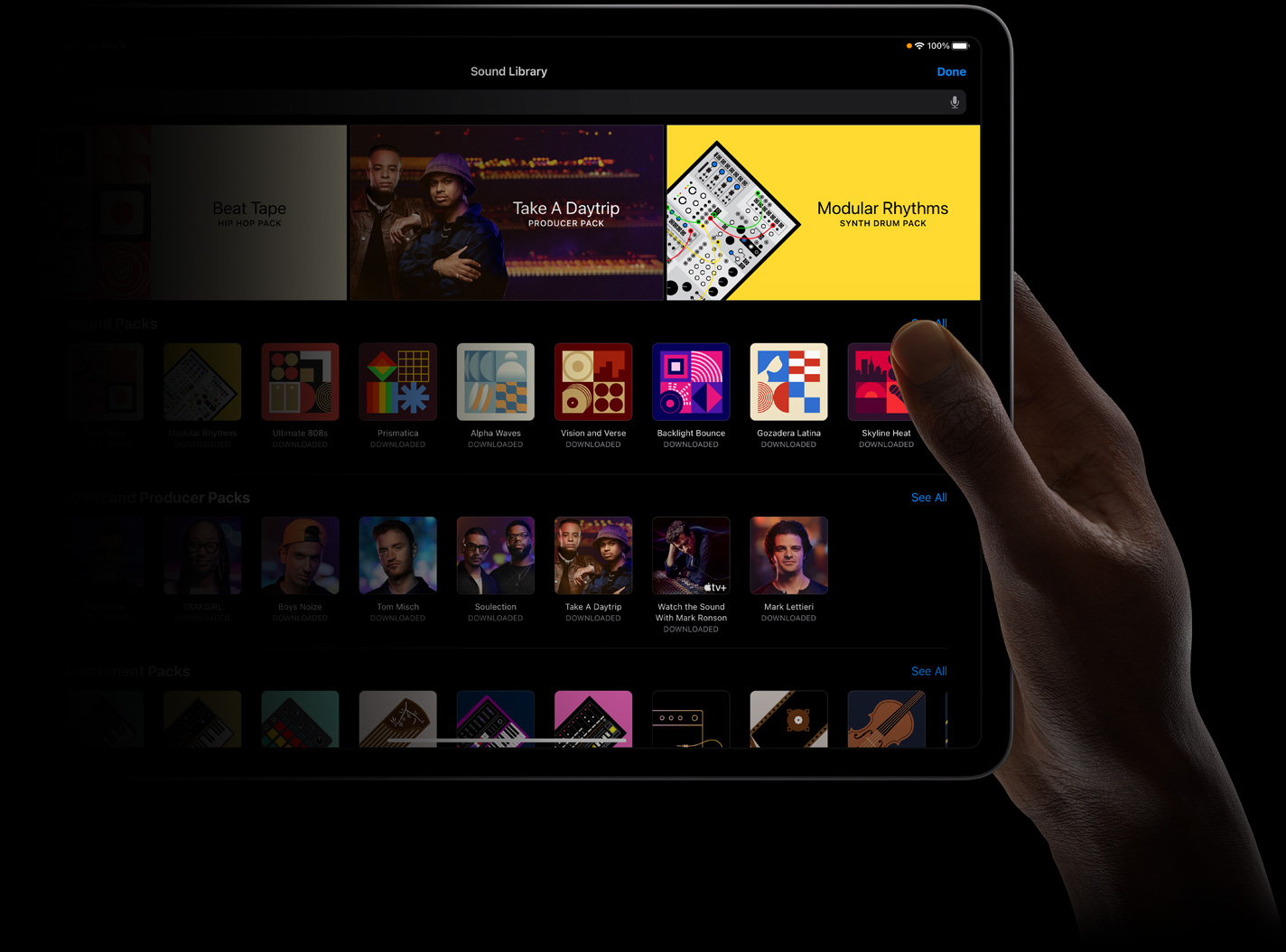 Una mano sostiene un iPad Pro que muestra una biblioteca de sonidos en la pantalla.
