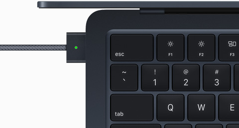 Ülaltvaade, kus on näha MagSafe kaabliga ühendatud MacBook Air toonis öösinine