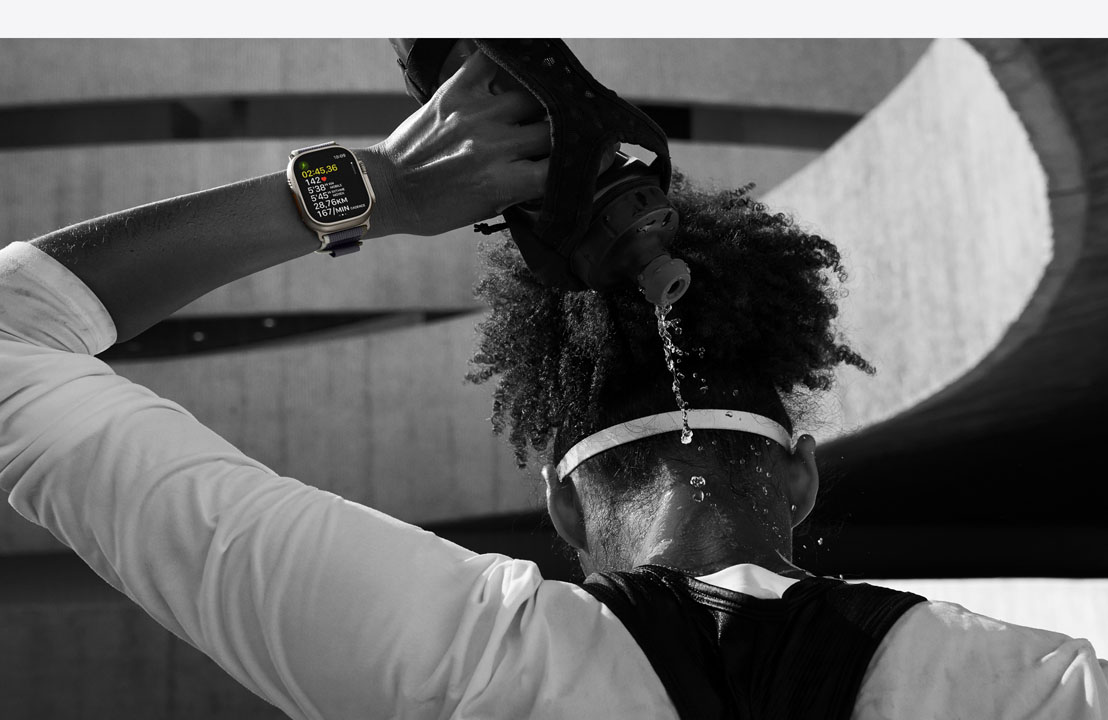 Une athlète portant une Apple Watch Ultra 2 se verse de l’eau sur la nuque.