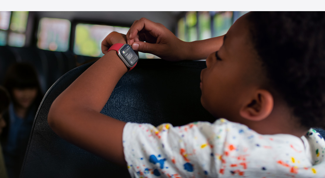 Un enfant lit un texto sur une Apple Watch SE.