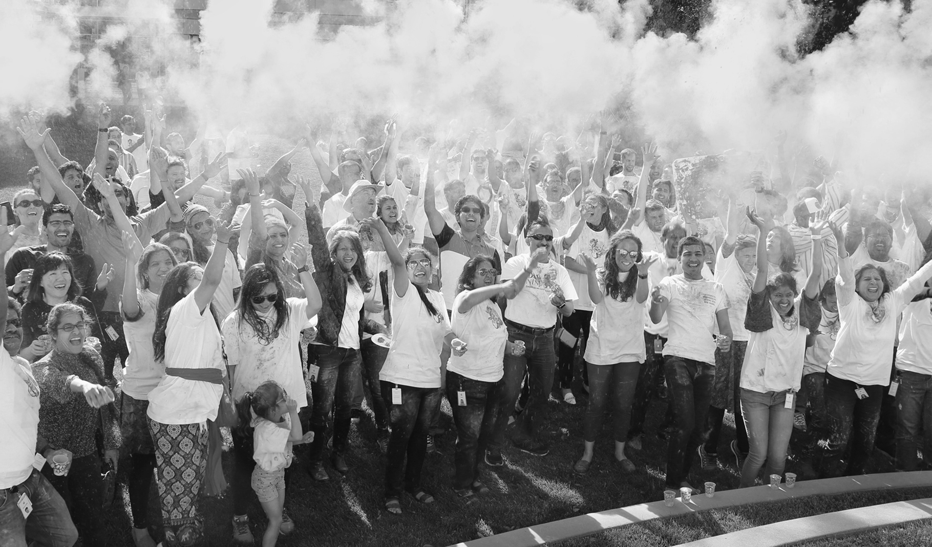 Foto de un gran grupo de empleados festejando en el exterior de un campus de Apple.