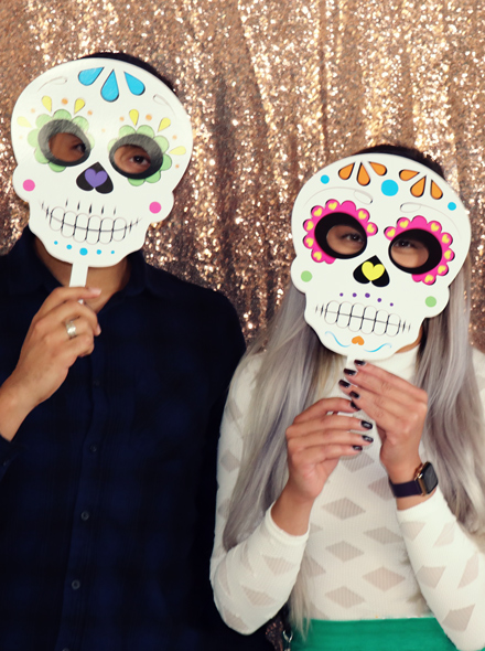 Photo de deux personnes portant chacune un masque de la Día de Muertos.