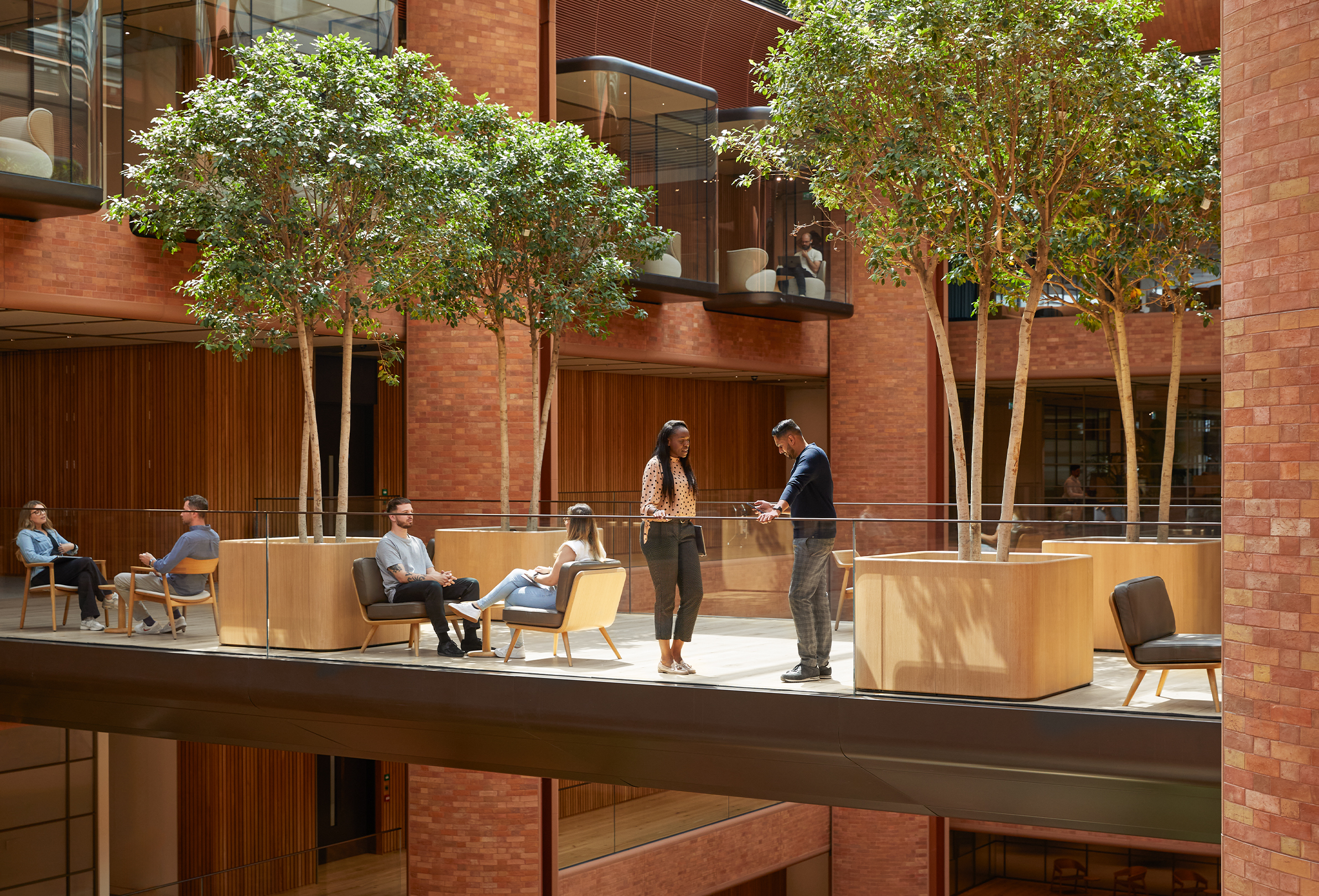 Multiple Apple team members gathered in different conversations in the Battersea atrium.