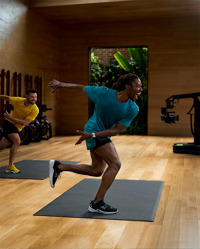 เทรนเนอร์ Apple Fitness+ กำลังนำออกกำลังกายหน้ากล้องในสตูดิโออัดวิดีโอ 