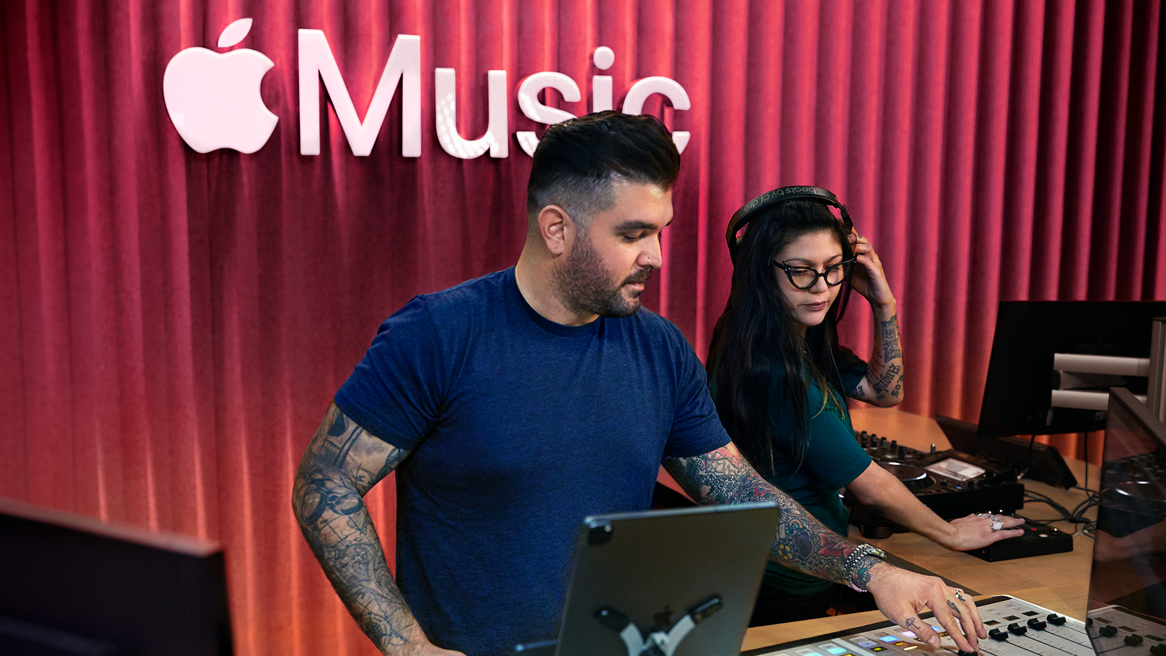 Dva zaměstnanci Apple používají mixážní pult ve studiu Apple Music.