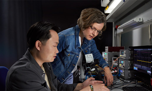 Ruth arbeitet mit einem Kollegen an einem Tisch im Engineering Lab an unserer Chiptechnologie.