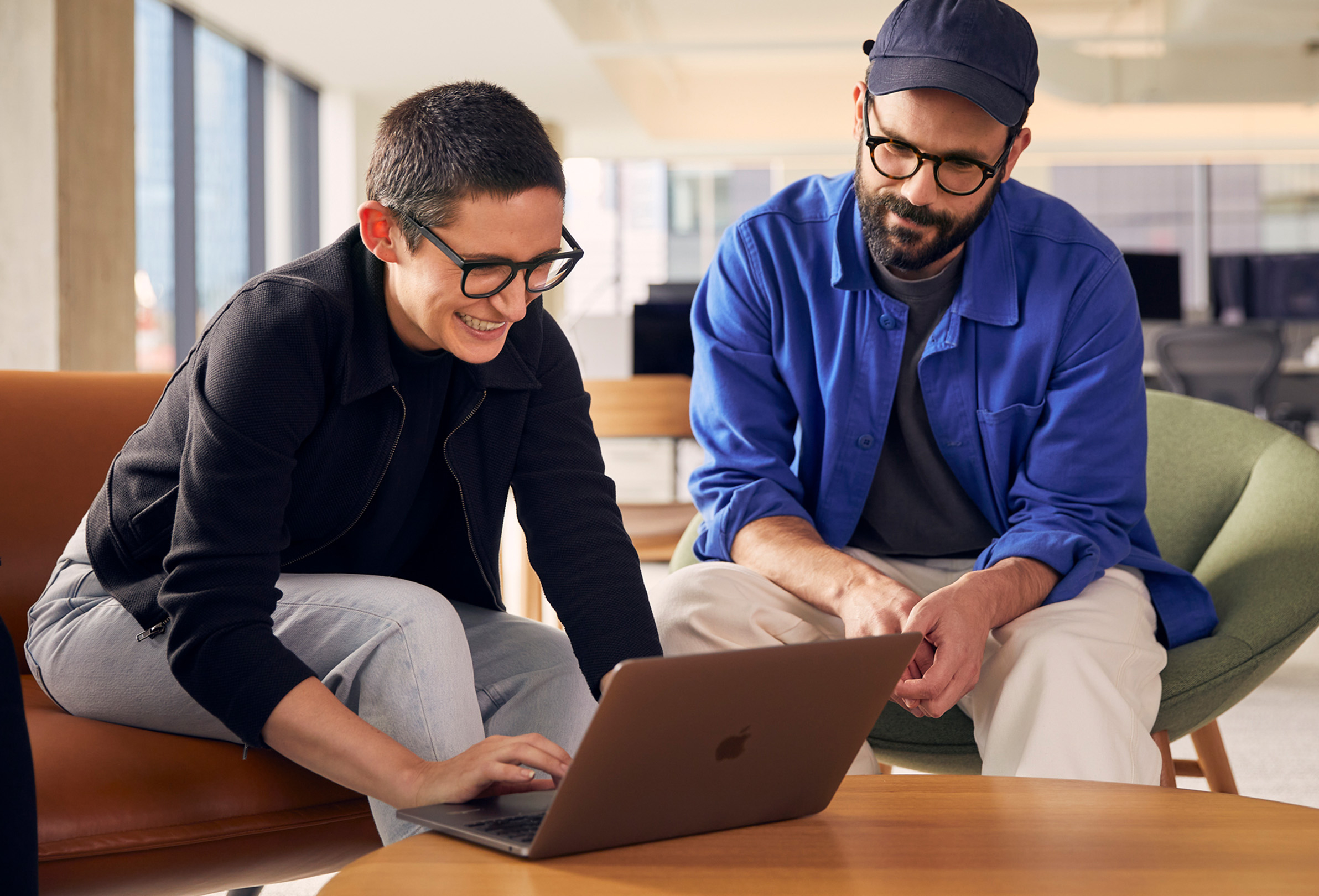 Dwoje pracowników Apple wykorzystujących MacBooka do współpracy.