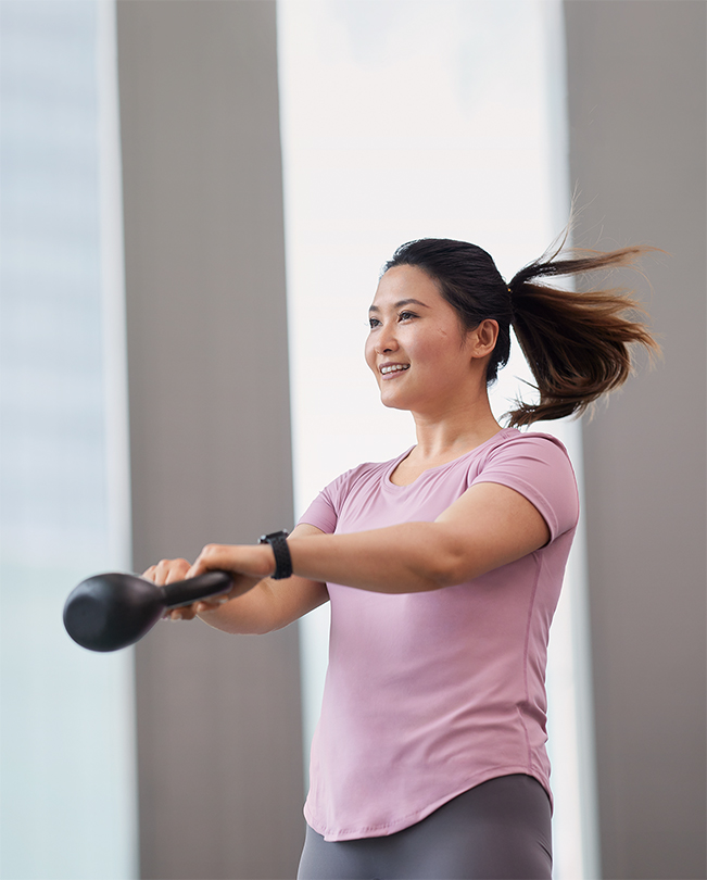 An Apple employee mid-motion while exercising with a kettlebell weight.