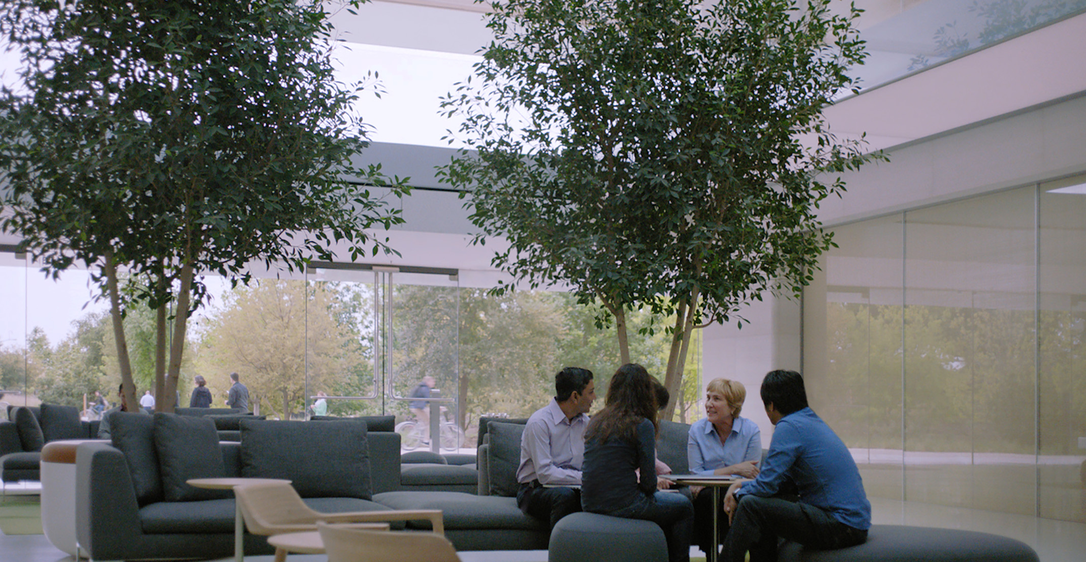 Luonnollisten kielien käsittelytiimiä johtava Giulia istuu pöydän äärellä muiden Applen työntekijöiden kanssa.