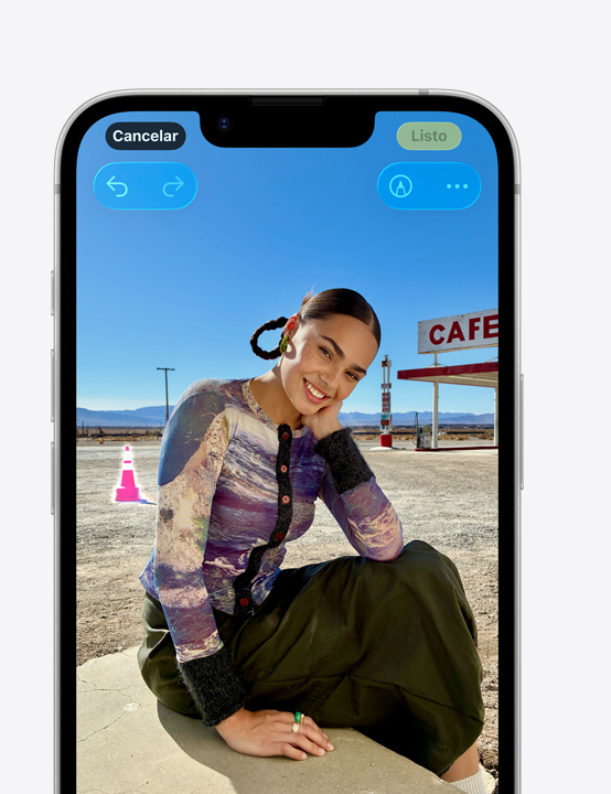 Pantalla de un iPhone, foto de una persona sonriendo en la playa, que muestra cómo eliminar un cono ubicado detrás con la herramienta Borrador