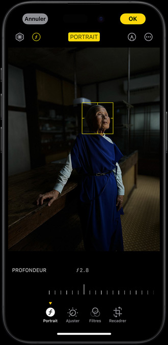Pro iPhone 15, показывающий портрет женщины, сфотографированной в слабо освещенном месте, точка, которую на лице выступают на лице