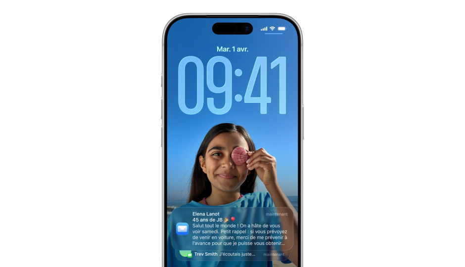 Écran verrouillé de l’iPhone avec photo, chiffres de l’heure en Liquid Glass, deux notifications apparaissent en bas de l’écran