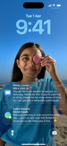 iPhone, five models, each model slightly overlapping the one next to it, far left screen shows a conversation with a background in Messages, second to the left screen shows Home Screen with colorful app icons, center model shows Lock Screen with photo, numerals for time in Liquid Glass, two notifications appear on bottom of screen, second to the right model shows clear Liquid Glass app icons, far right model shows music player in Liquid Glass