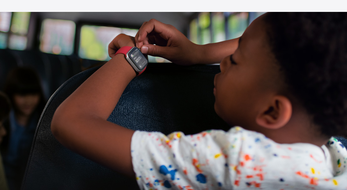 Apple Watch SEに表示されたテキストを読んでいる子ども。