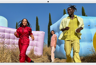 Three people in bright outfits, surrounded by colorful inflatable shapes