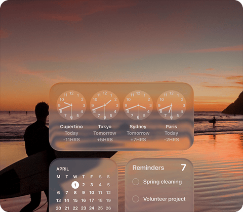 Liquid Glass Clock, Calendar, Reminders, and Weather widgets on macOS Tahoe screen over a scene of a surfer walking on the beach at sunset