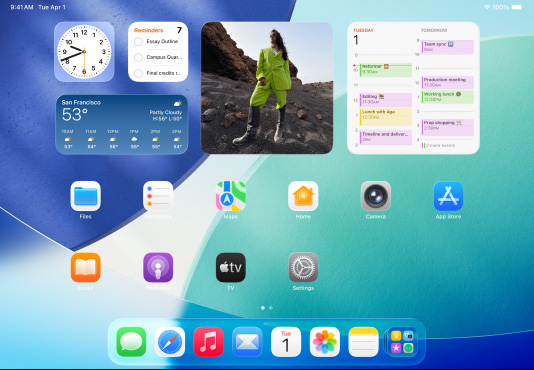 ثلاثة موديلات iPad بوضع أفقي، مع موديل في الوسط أمام الاثنين الآخرين، وقلم Apple متصل مغناطيسياً بأعلى الموديل الأوسط؛ الشاشة الوسطى تعرض الشاشة الرئيسية التي تتميز بأيقونات تطبيقات ملونة مع تأثير Liquid Glass، والشاشة اليسرى تعرض تطبيق المعاينة، والشاشة اليمنى تعرض الشاشة الرئيسية مع ظهور ملفات تتفرّع عمودياً من شريط الأيقونات
