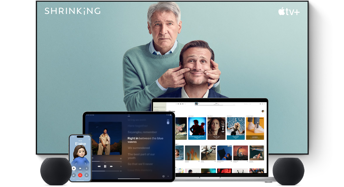 Large flat-screen television showing two male characters from the Apple TV+ series Shrinking. A MacBook Pro, an iPad, an iPhone and a Midnight HomePod mini are arranged in front.