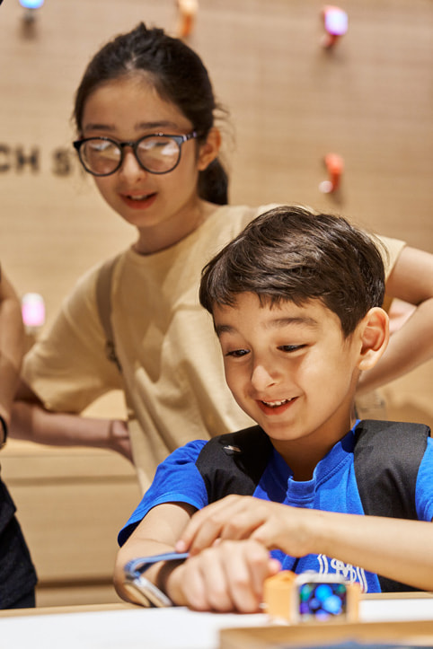 Två unga kunder utforskar de senaste Apple Watch-modellerna.