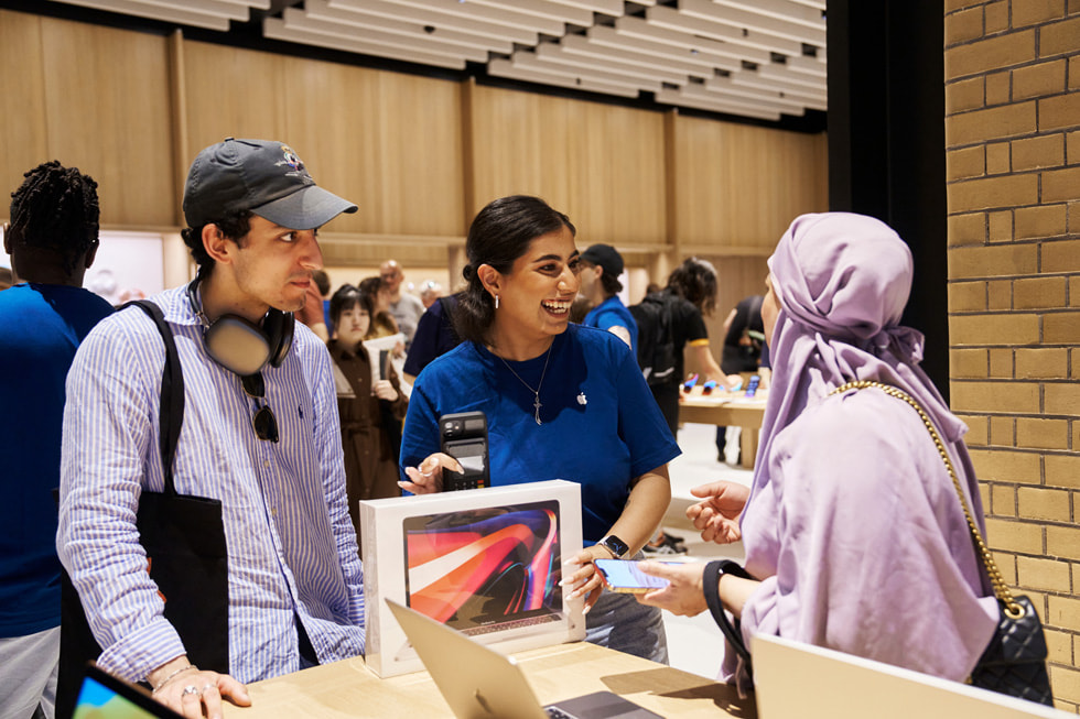 En Apple-medarbetare hjälper en kund att köpa en ny MacBook Pro.