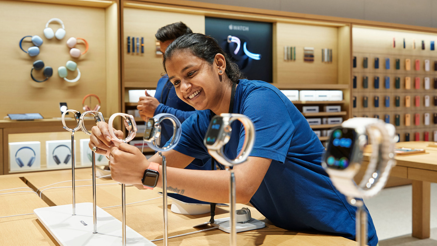 Une membre de l’équipe de la boutique Apple BKC ajuste la nouvelle Apple Watch Series 9 sur une table de présentation.