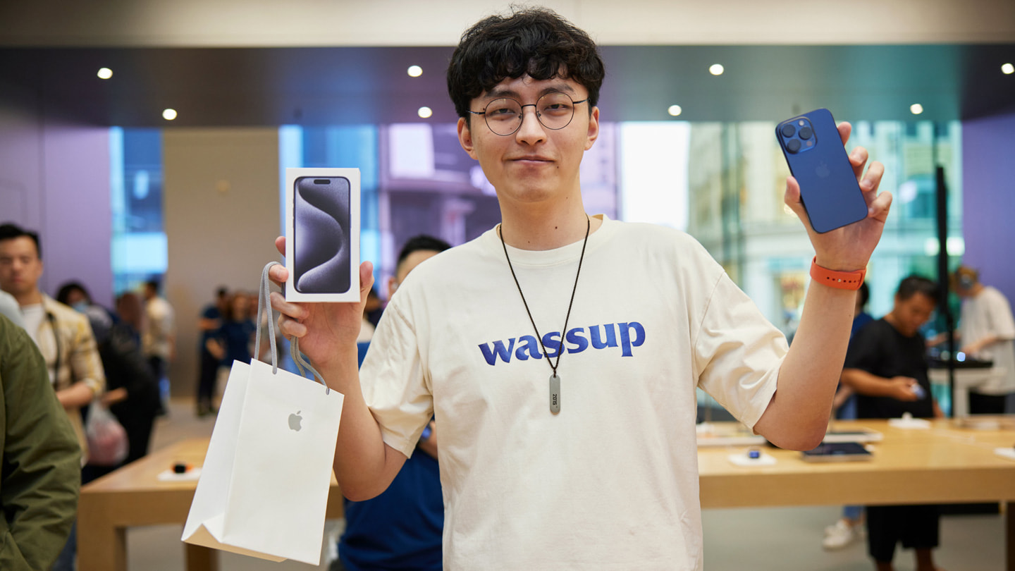 一位年輕顧客展示他購買的藍色 iPhone 15 Pro Max。