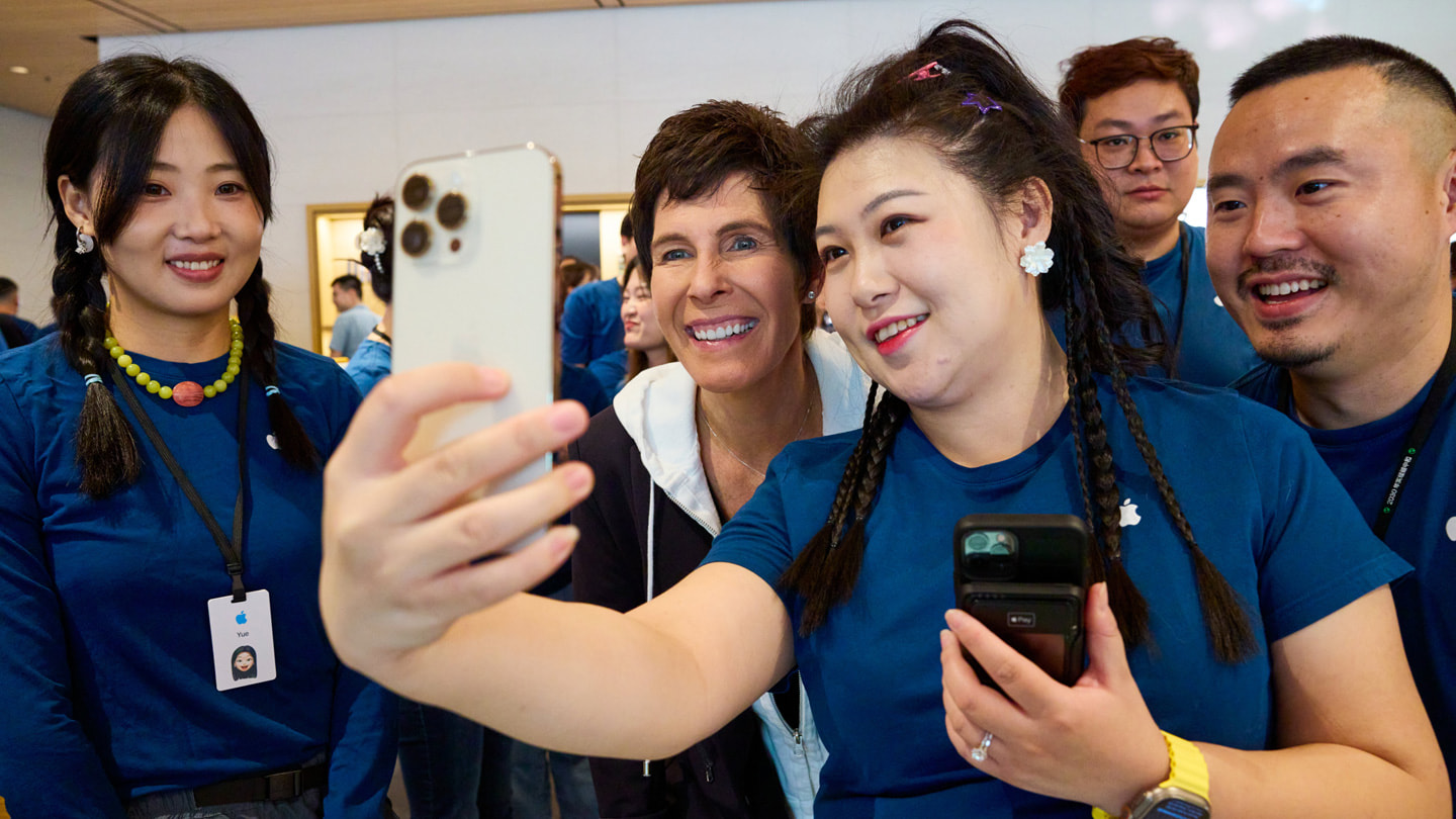 En medarbetare tar en selfie tillsammans med bland annat Deirdre O’Brien med en vit iPhone 15 Pro.