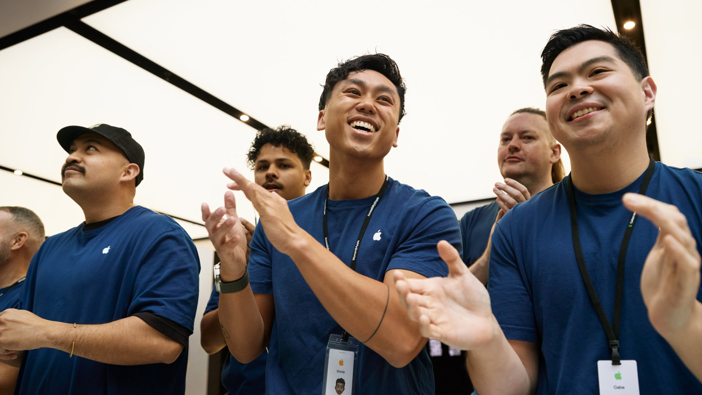 Des membres de l’équipe Apple Sydney en Australie applaudissent la clientèle à l’intérieur de la boutique.
