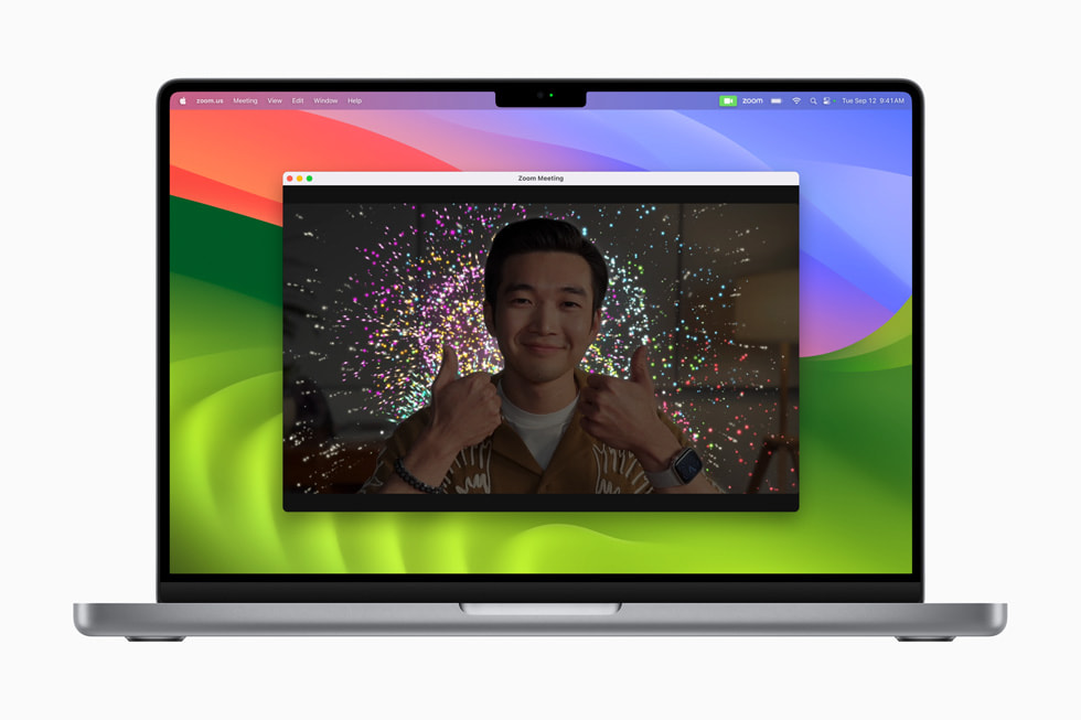 Rapat Zoom di MacBook Pro menampilkan kembang api di belakang presenter.