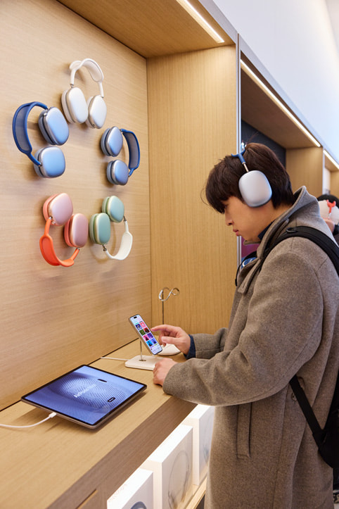 A customer tests out the AirPods Max line-up.