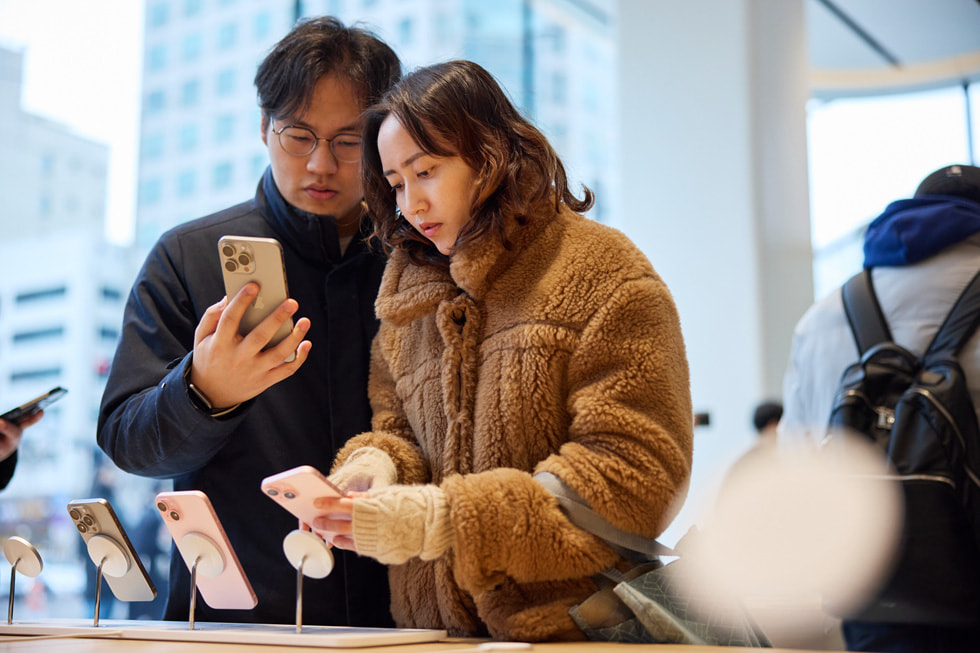 Dos clientes miran la línea del iPhone 15.