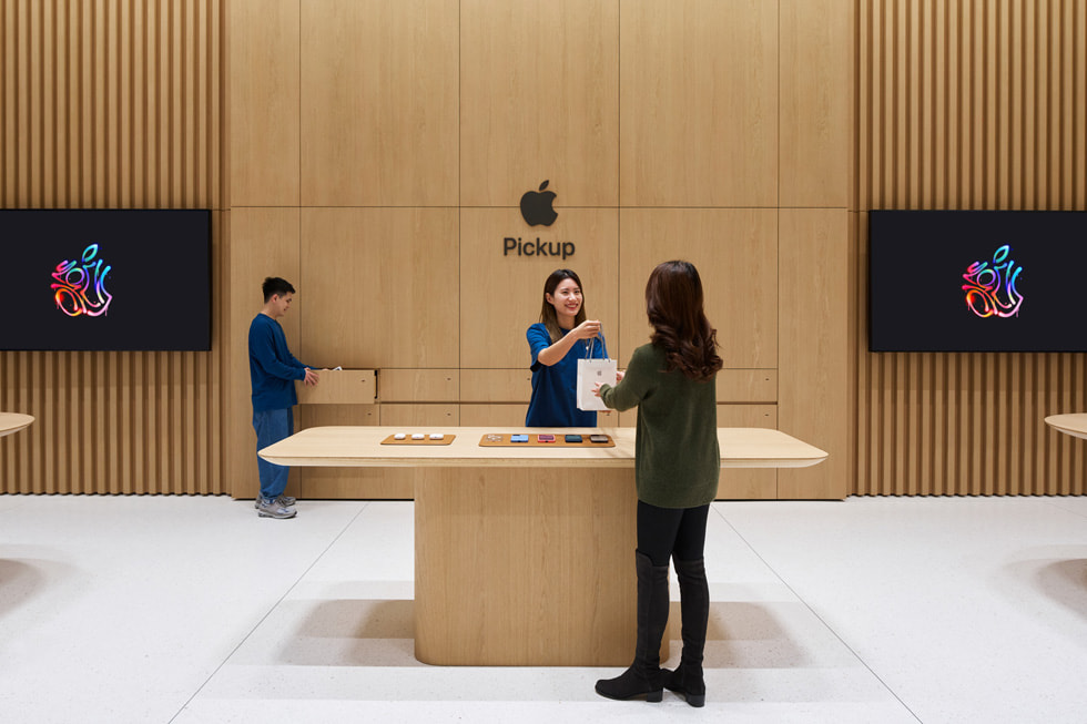 一名顧客與團隊成員於 Apple 取貨專區交談。