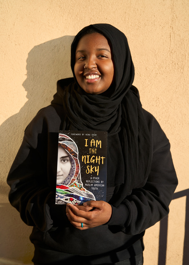 Sasa Aakil, autrice de Shout Mouse Press, pose avec un exemplaire du livre I Am the Night Sky, dont elle est cosignataire.