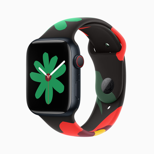Apple Watch Series 9 avec les nouveaux bracelet et cadran de la Collection Black Unity. Sur l’image, le cadran arbore une petite fleur verte.