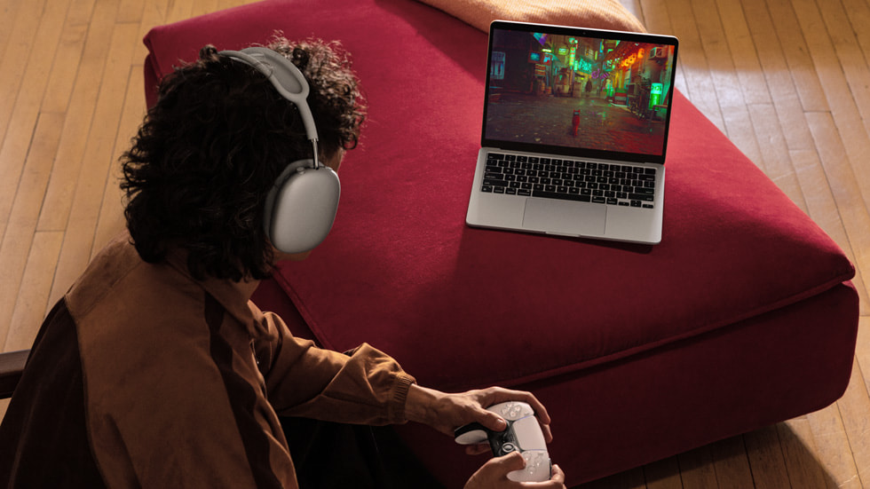 En person med hovedtelefoner på spiller et spil på den nye MacBook Air.