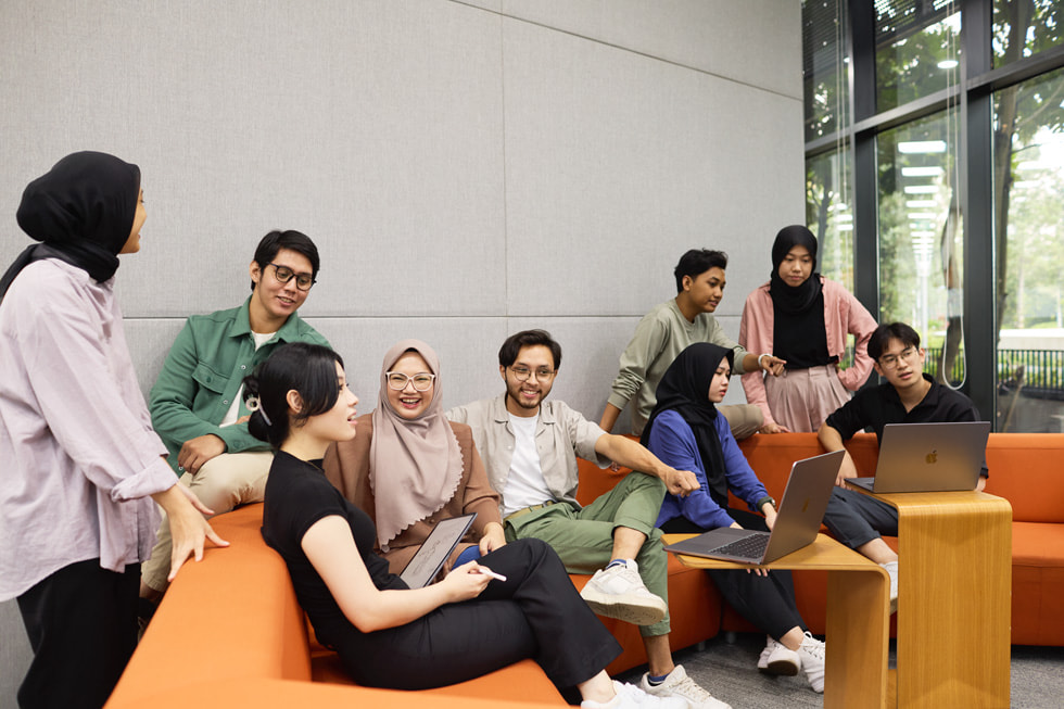 Dziewięcioro uczestników programu Apple Developer Academy, których sfotografowano w sali lekcyjnej.