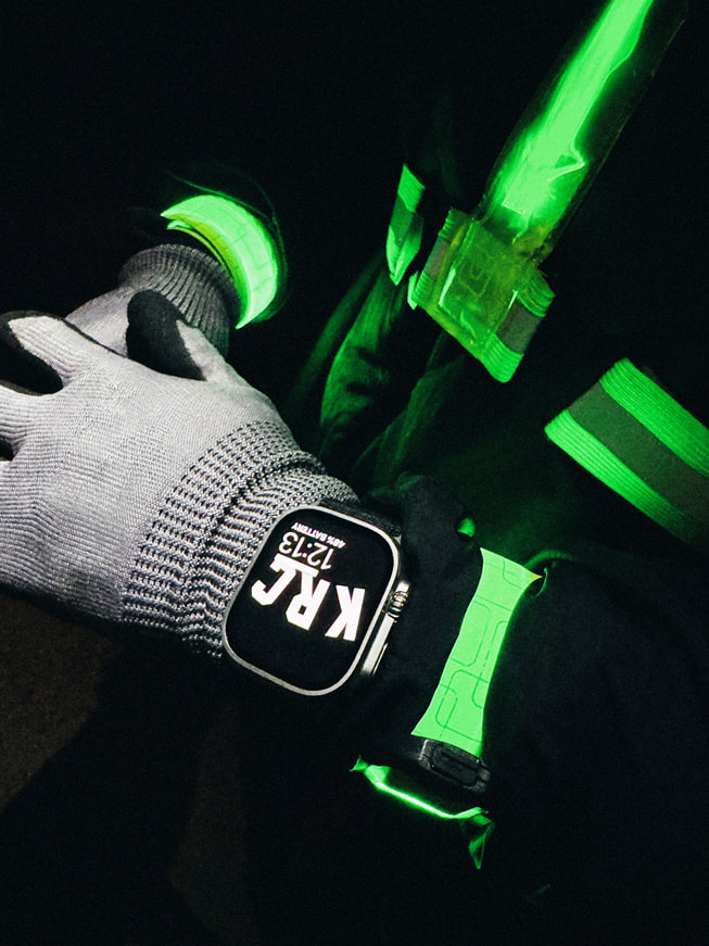 A close-up of a runner's wrist showcasing Apple Watch Ultra at night.