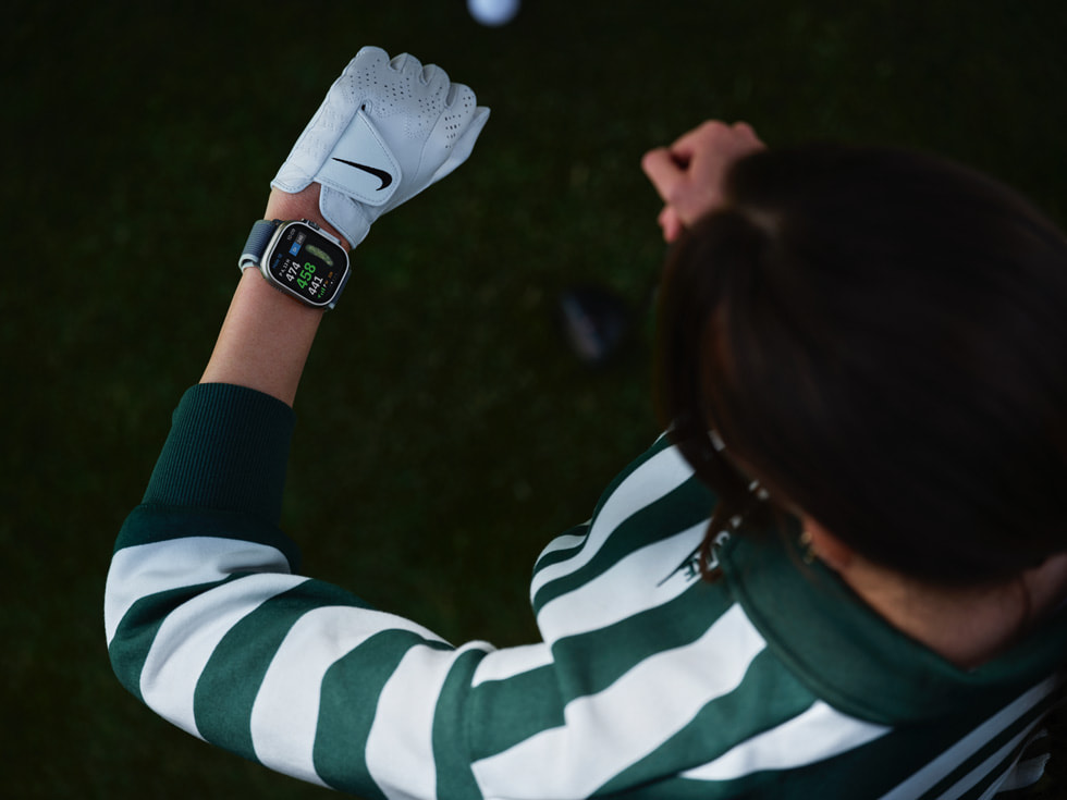 Pohled shora na golfistu dívajícího se na Apple Watch