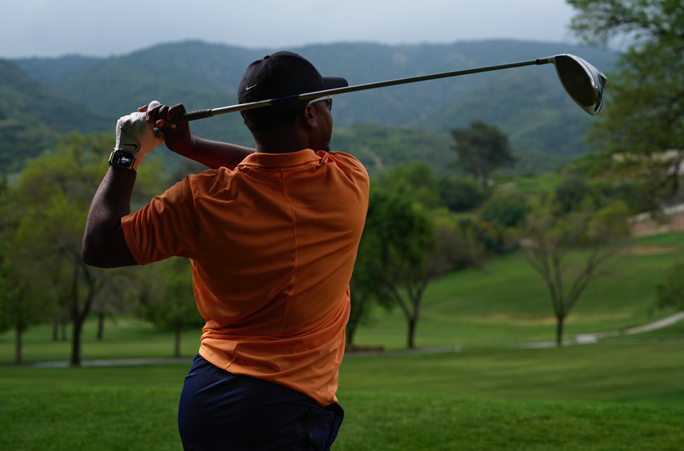 En golfspiller med Apple Watch på håndleddet, der svinger en golfkølle, vises.